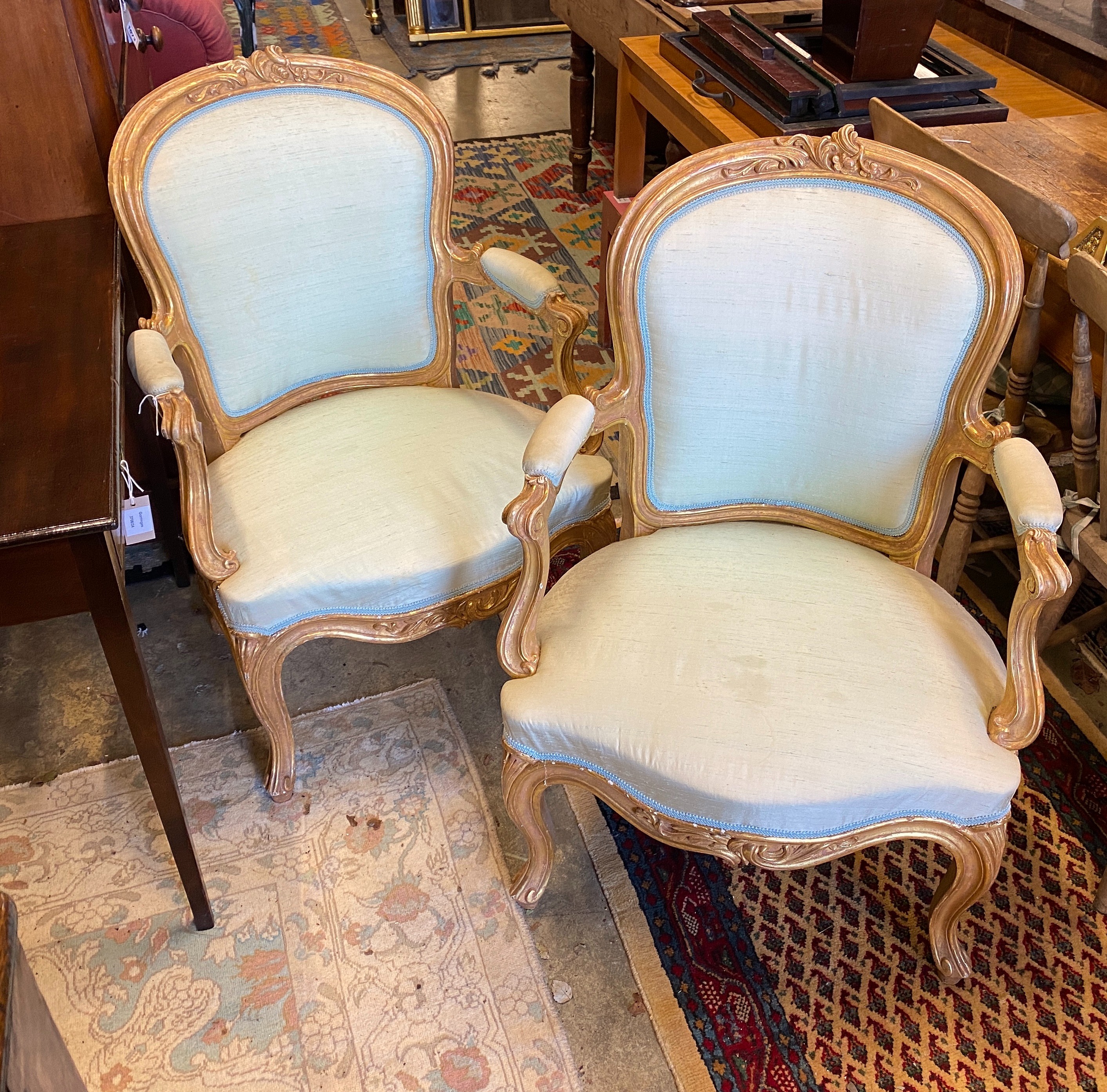 A pair of 19th century Louis XV design carved giltwood fauteuils, width 64cm, depth 50cm, height 94cm